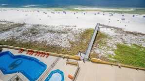 A beach with a swimming pool and a lifeguard tower. - Phoenix Iii 3074 2 Bedroom Condo (Orange Beach)