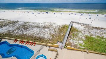 A beach with a swimming pool and a lifeguard tower.