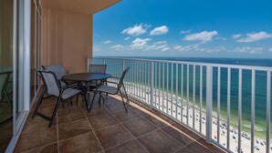 A balcony with a view of the beach and ocean.