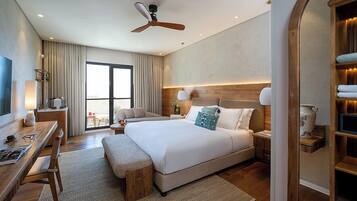 A hotel room with a large bed, bedside tables, a desk, and a chair.