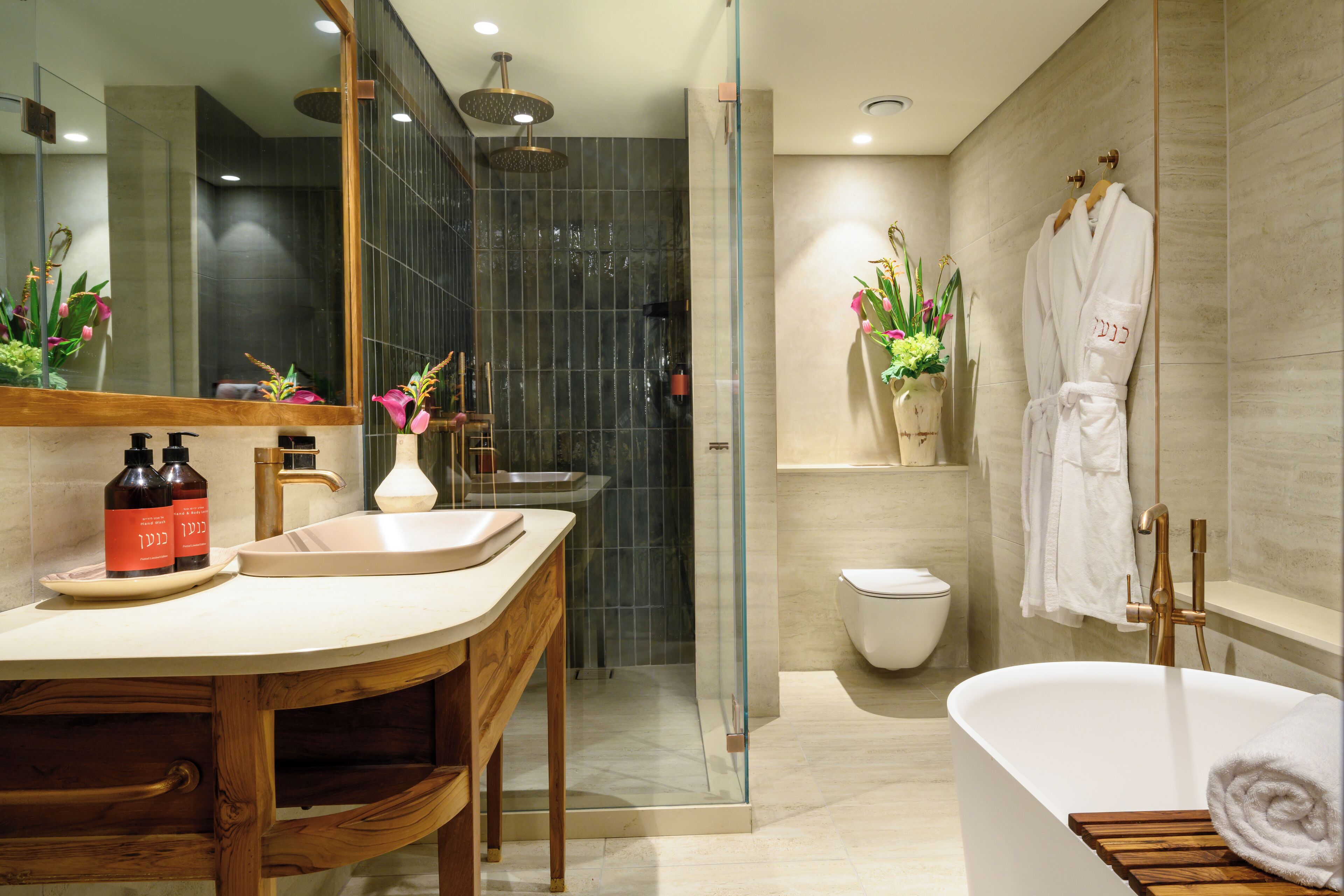 A modern bathroom with a wooden vanity, a glass-enclosed shower, a white bathtub, and a toilet.