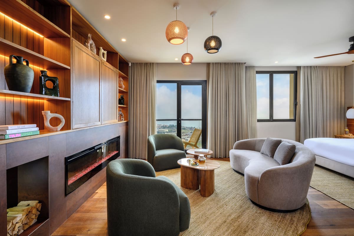 A modern living room with a fireplace, a sofa, a coffee table, and a bookshelf.