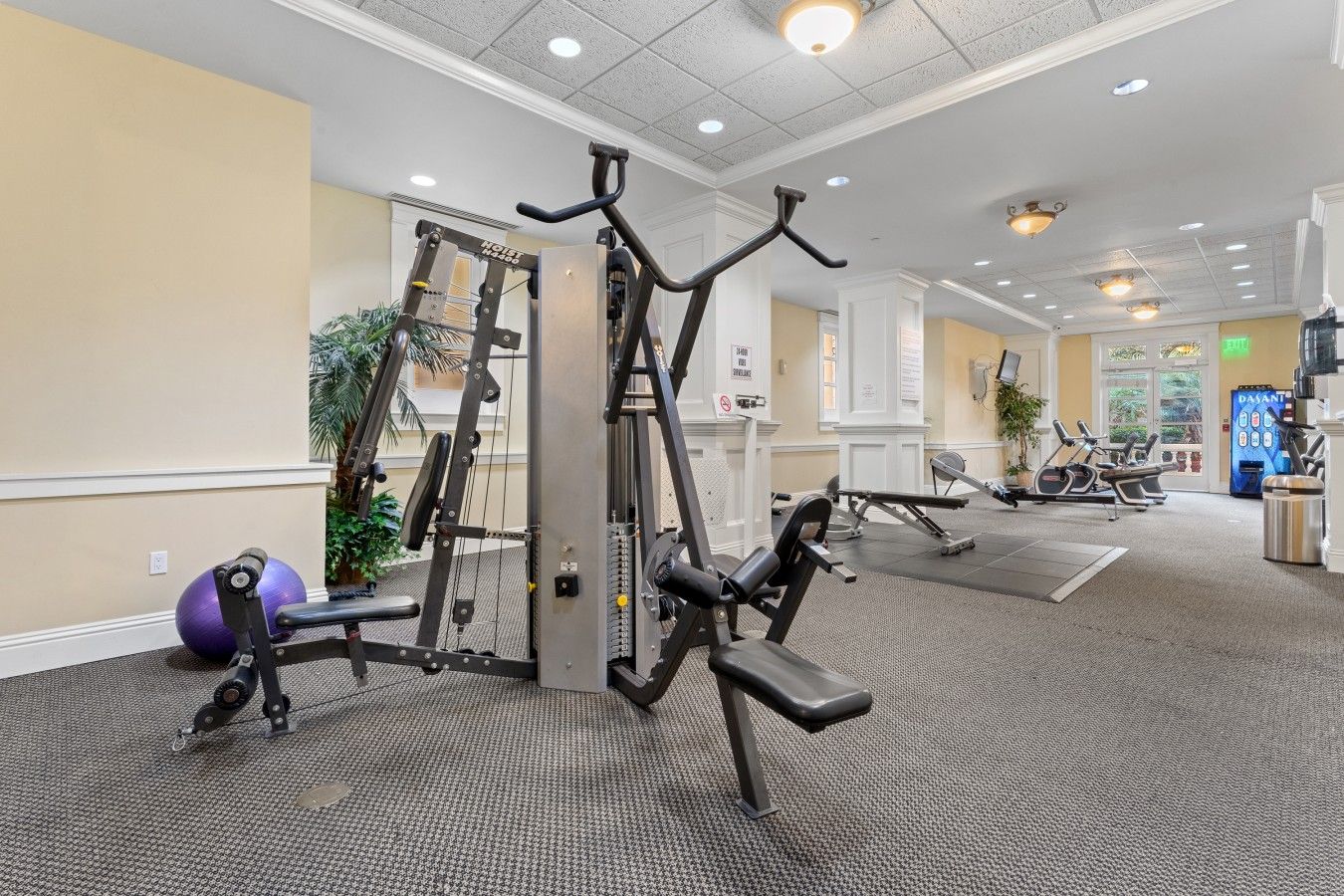 A gym with cardio machines, weight training equipment, and a stationary bike.