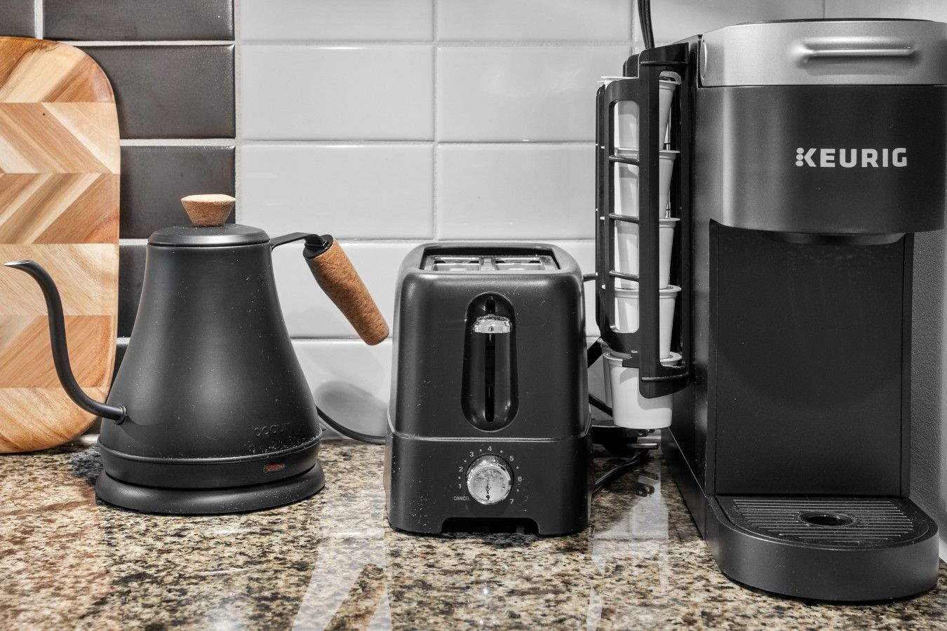Una cocina equipada con cafetera, tostadora y hervidor.