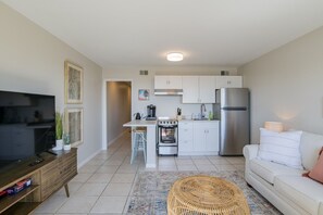 Een moderne keuken met witte kasten, een roestvrijstalen koelkast en een inbouwoven.
