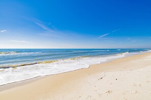 A beach with a clear sky and calm sea. - 🌊 Beachfront Bliss on the Fort Morgan Peninsula – Chic Condo with Panoramic Gulf Views (Gulf Shores)