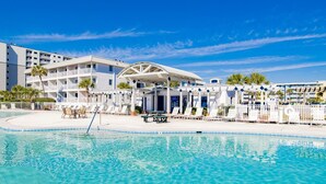 Ett hotell med en swimmingpool, solstolar och ett avskärmat område.