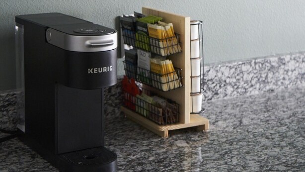 A Keurig coffee maker on a granite countertop with a coffee pod holder containing various pods. - ✨ Stylish Beach Condo – Sleeps 6 in family friendly Gulf Place, Santa Rosa Beach (Santa Rosa Beach)