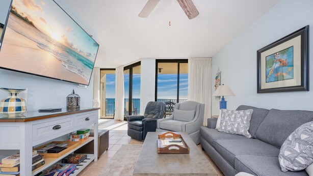 A living room with a sofa, a coffee table, a TV, and a bookshelf.