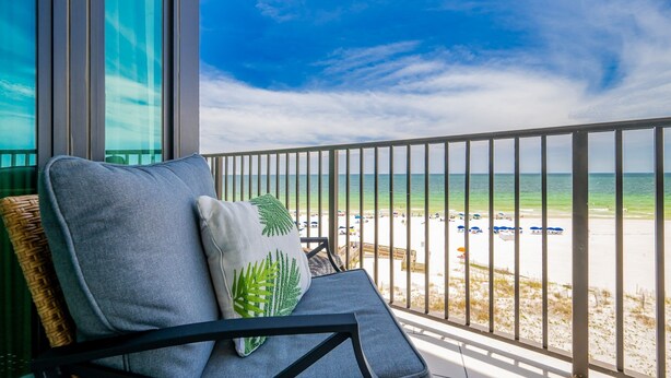 Een balkon met uitzicht op het strand en de oceaan.