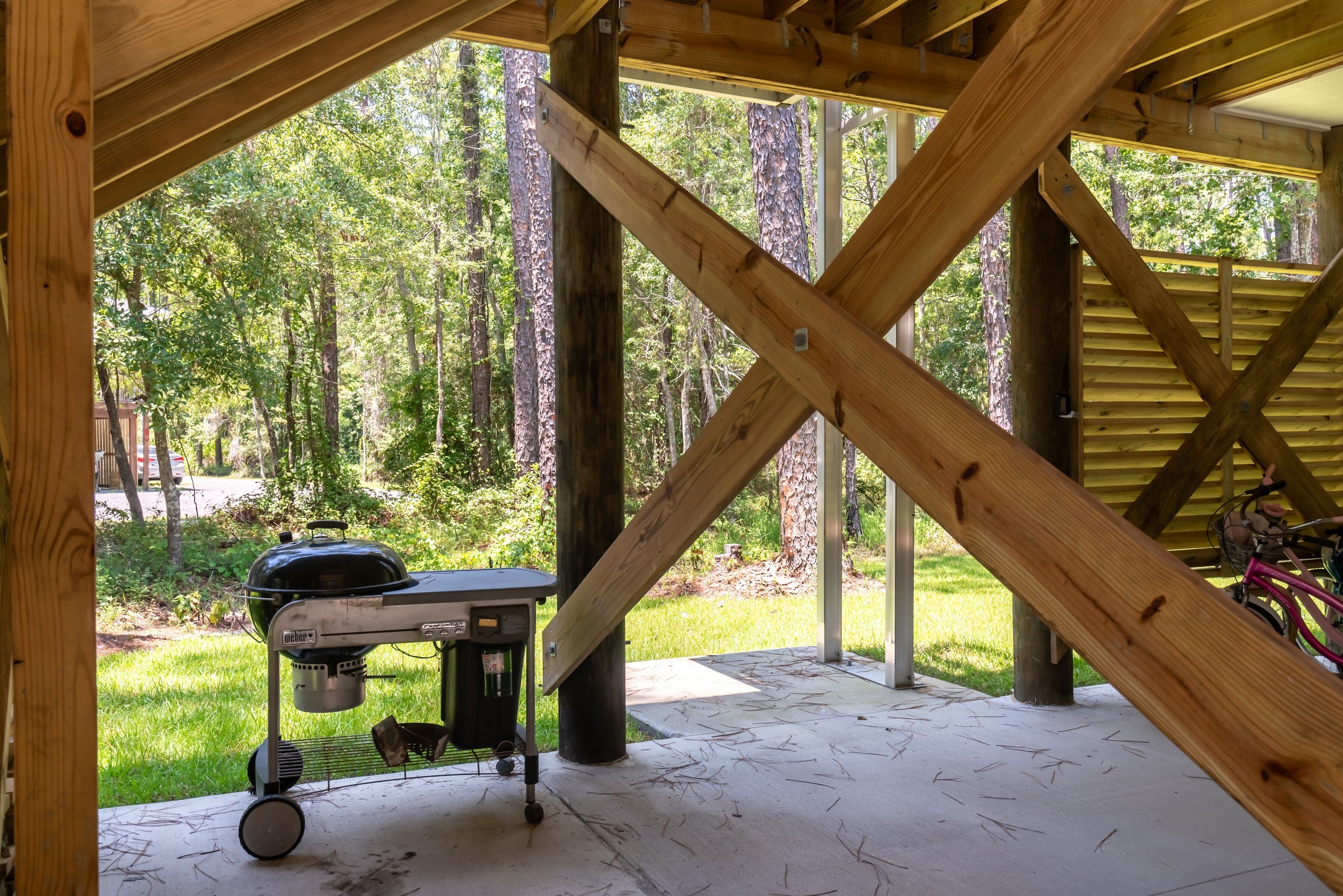 An outdoor wooden deck with a grill and a bicycle.