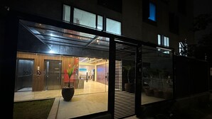 Un edificio moderno con entrada de vidrio, una zona de recepción y una planta en maceta.