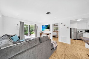Relax in this stylish living space with a comfortable sofa, flat-screen TV, and dining area.