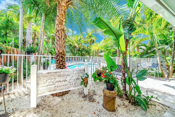 Relax in a serene pool area surrounded by lush greenery and a well-maintained garden.
