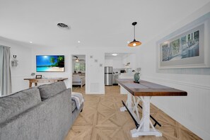 Relax in this stylish living space with a comfortable sofa, dining table, and flat-screen TV.
