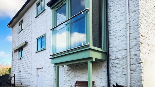 A white building with a green window frame and a balcony. - 2 bedroom accommodation in Ruswarp, near Whitby (Ruswarp, near Whitby)