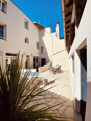 A courtyard with a pool table, outdoor seating, and a staircase leading to the upper floors. - Maison Malo Leone (Mauléon)