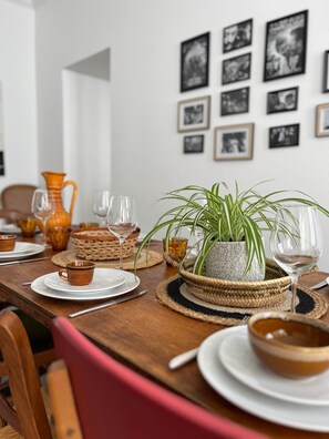 A dining table set with plates, glasses, and a potted plant. - Maison Malo Leone (Mauléon)