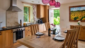 Una cocina moderna con armarios de madera, una isla grande y un comedor con mesa y sillas de madera.