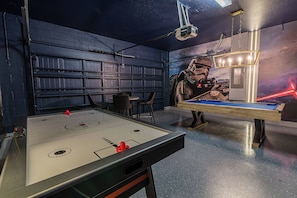 A room with a foosball table, a pool table, and a mural of a space scene. - Beautiful Home with private Pool - SPA - Game Room (Davenport)