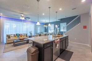 Relax in this spacious living area with a central kitchen island, sofa, and coffee table.