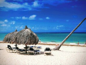 A beach with thatched umbrellas and lounge chairs. - Ark Villa is located 2 minutes from Downtown Punta Cana. (Punta Cana)