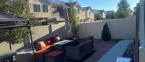 A patio area with outdoor furniture, a table, and a tent.
