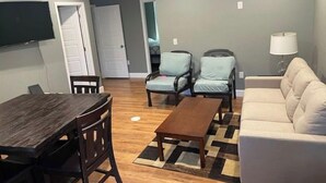 A living room with a wooden dining table, two armchairs, a sofa, and a coffee table. - Walkout basement and easy access to I-70 and DIA (Denver)