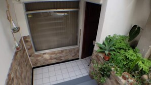 Una escalera con vista a un balcón, plantas en macetas y un suelo de baldosas.