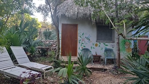 Un petit espace jardin agrémenté d’une porte en bois, d’un banc et d’une chaise.