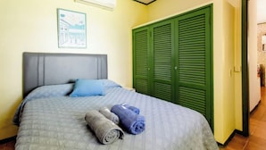 Ein Schlafzimmer mit einem Bett, einer grünen Tür und einer Wand-Klimaanlage.
