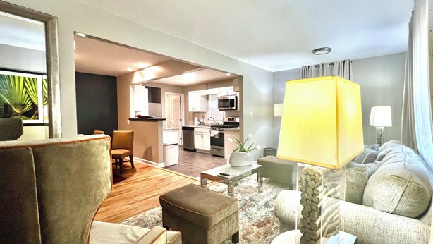 Una habitación de hotel moderna con sala de estar, comedor y cocina.