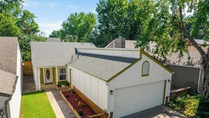 Une propriété résidentielle dotée d’un garage, d’une petite dépendance attenante et d’une pelouse bien entretenue.