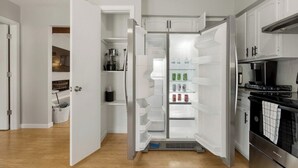Une cuisine moderne équipée d’un réfrigérateur encastré, d’une cuisinière et d’un four à micro-ondes.