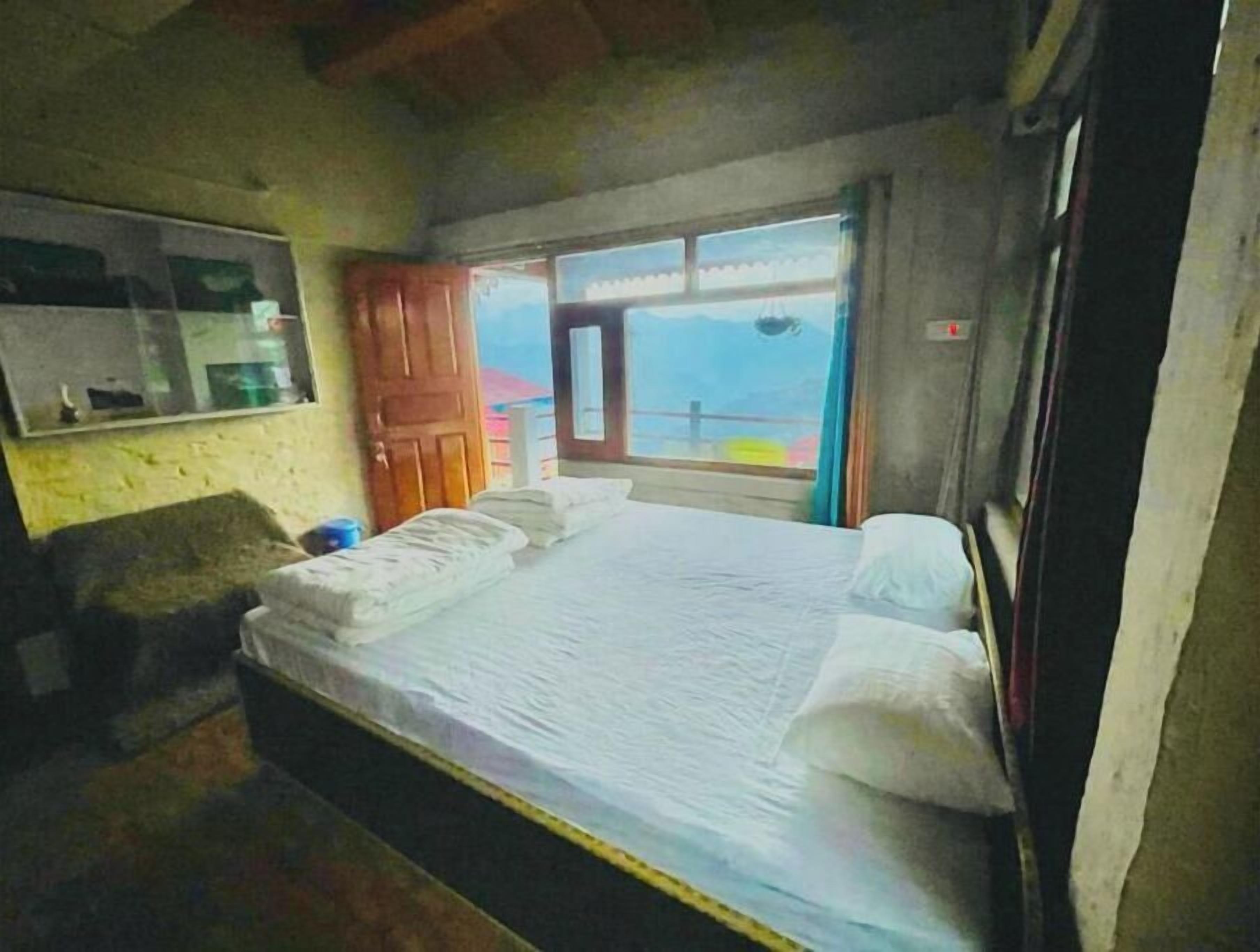 Ein Schlafzimmer mit Bett, Fenster und Tür.
