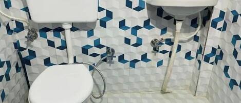 A small bathroom with a toilet, a sink, and a shower.