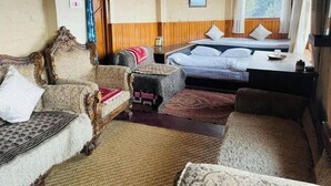 Una habitación con una cama, dos sofás, una mesita y un trofeo de caza en la pared.