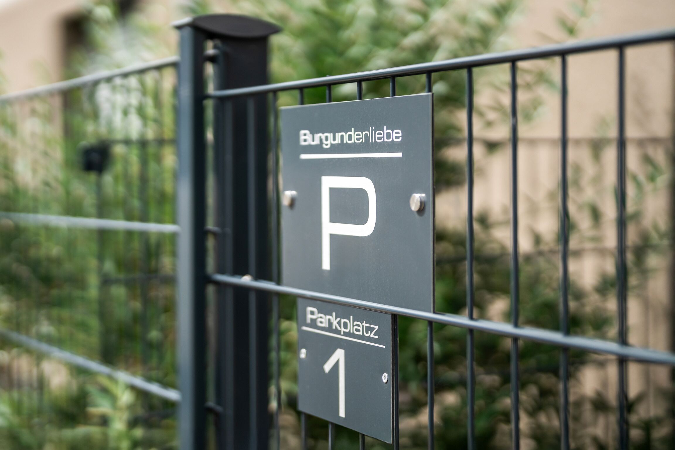 A parking sign with the text "Burgunderliebe" and "Parkplatz 1".