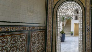 An interior corridor with a tiled wall, an ornate archway, and a staircase leading to an upper level. - Estudio Amor BRUJO by Cadiz4Rentals (Cádiz)
