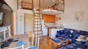 A compact living space with a kitchen, dining area, and a sofa. - Holiday apartment mit Klimaanlage und WLAN (Baška)