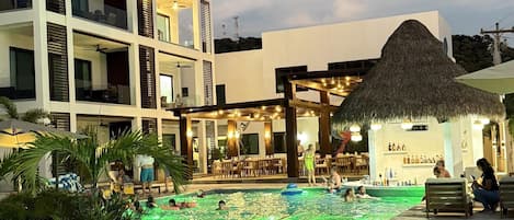 Een buitenzwembad, parasols bij het zwembad en ligstoelen