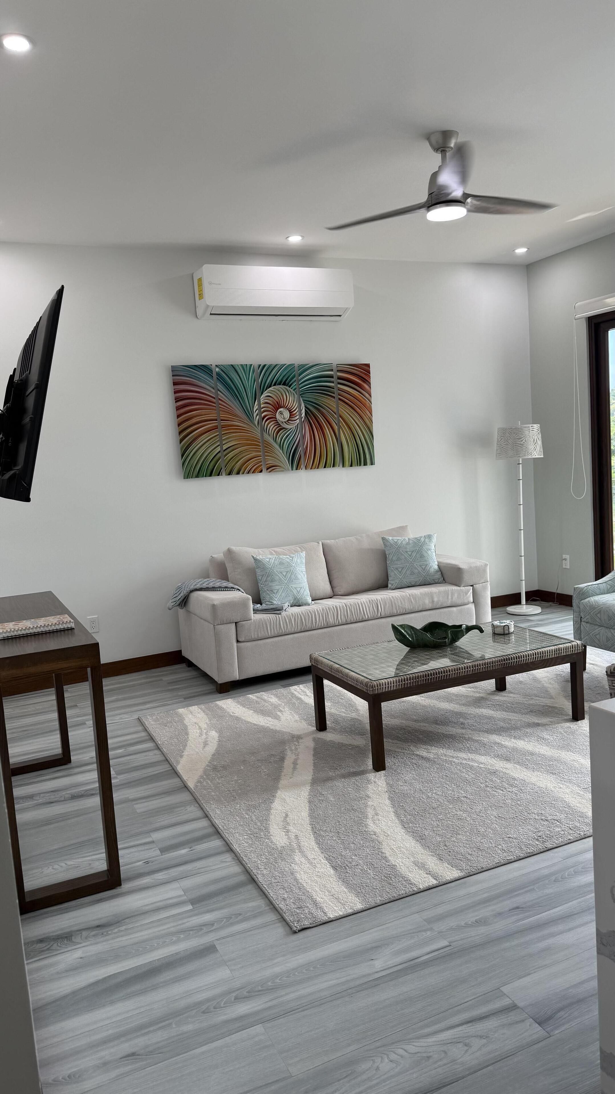 A modern living room with a sofa, coffee table, and artwork on the wall.