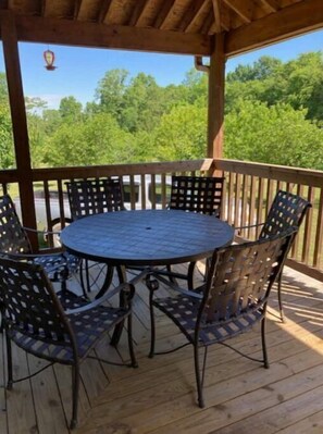 Relax in a serene outdoor setting with a round table and six comfortable chairs.