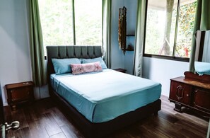 A bedroom with a bed, a dresser, and a window.