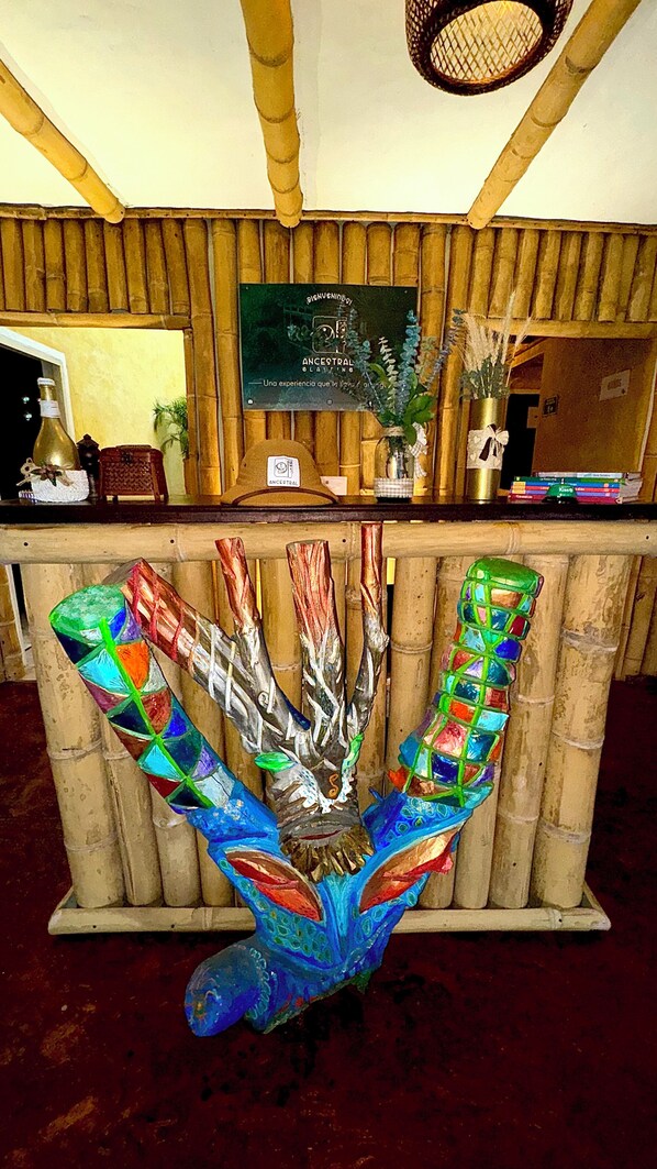 A reception desk with a decorative glass sculpture in the center. - Ancestral Glamping (Barbosa)