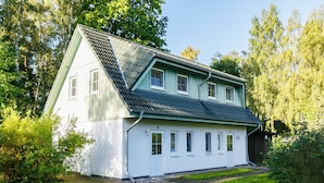A two-story house with a steeply pitched roof, white exterior walls, and a small porch. - Im Kiefernweg DHH 21 by Interhome (Zinnowitz)