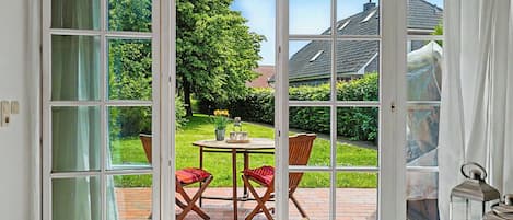 A room with a large sliding glass door leading to an outdoor patio with a table and chairs.