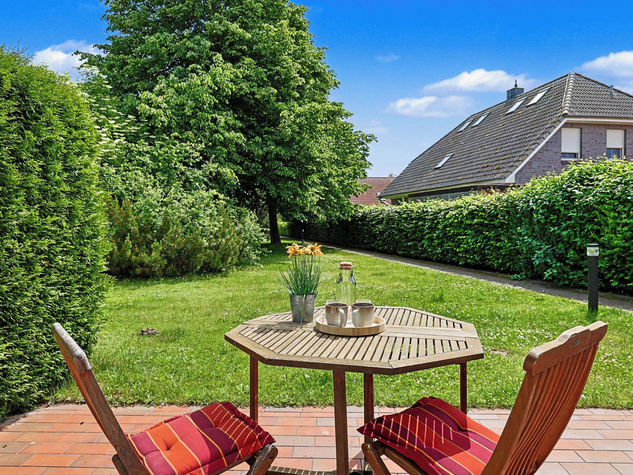 A patio with a round table, two chairs, and a bottle of water.