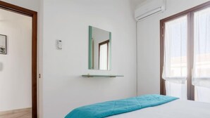 Ein Schlafzimmer mit einem Bett, einem Spiegel und einer Klimaanlage.