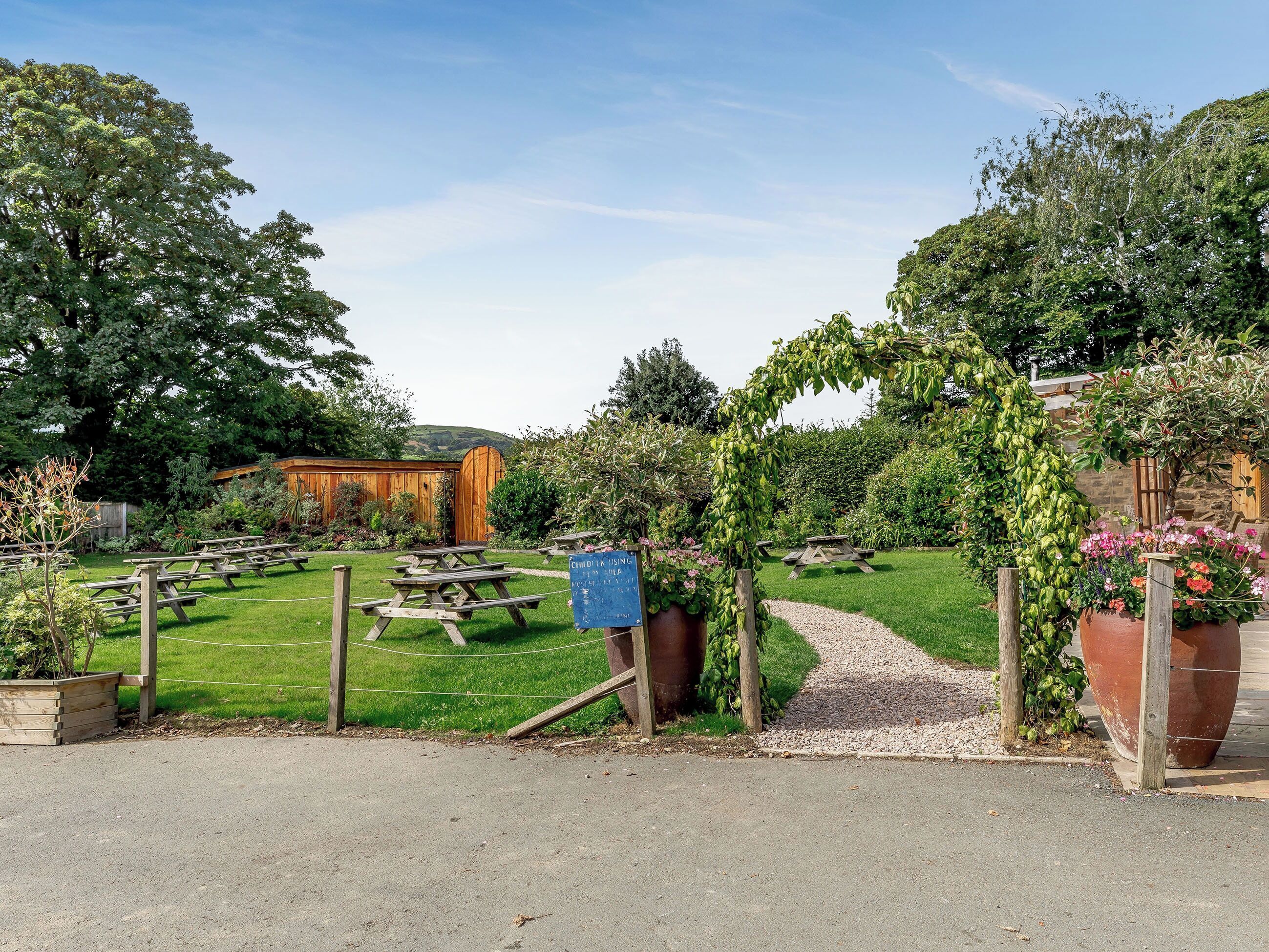 A picnic area with wooden benches and a sign indicating child-friendly facilities.